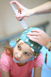 Doctor setting up EEG cap on pediatric patient
